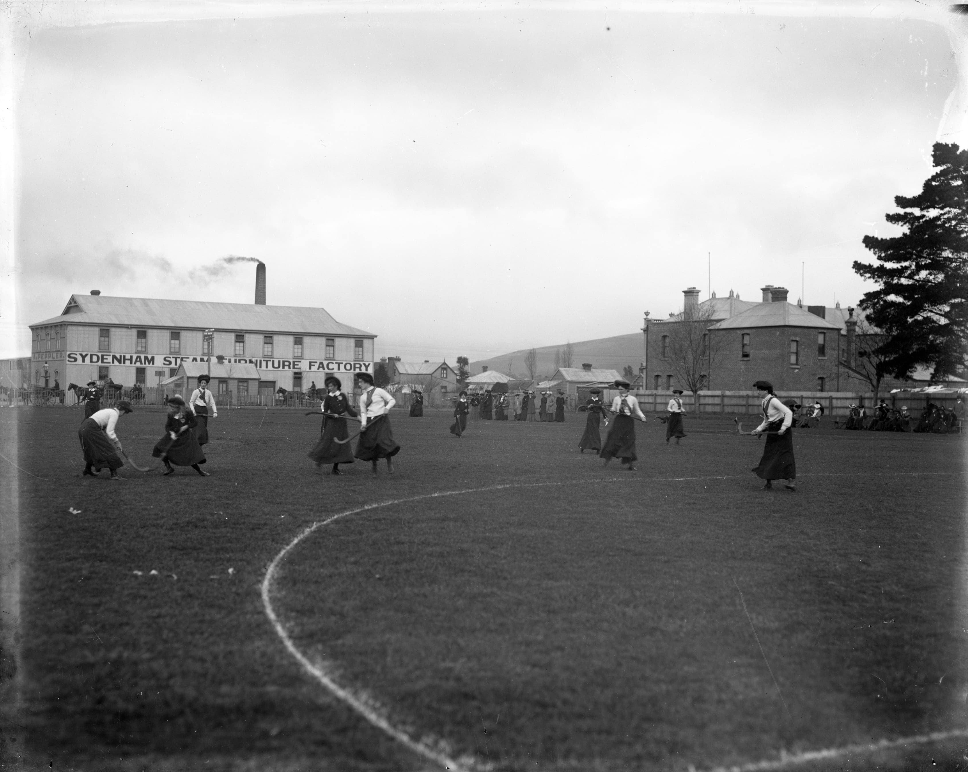 Women playing field hockey, circa 1900